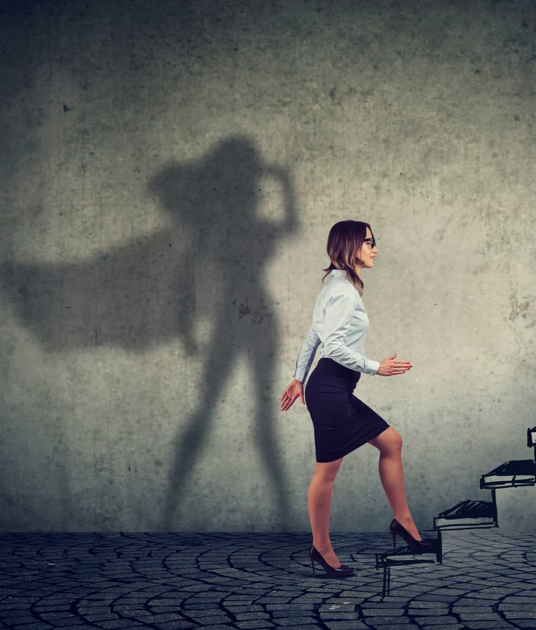 istock 1081572424 an image of a business woman and her shadow is a depiction of a super hero business woman stepping up on stairs climbing to success on gray wall background.