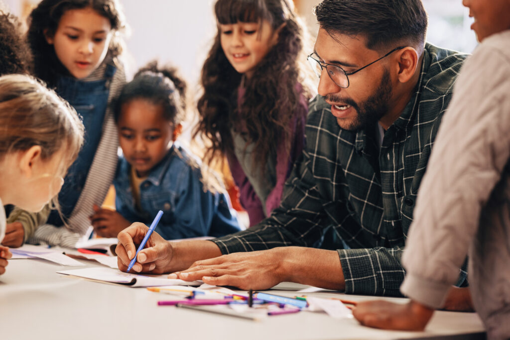 Image of a teacher surrounded by books, representing the mental health challenges educators face and the need for support and resources.