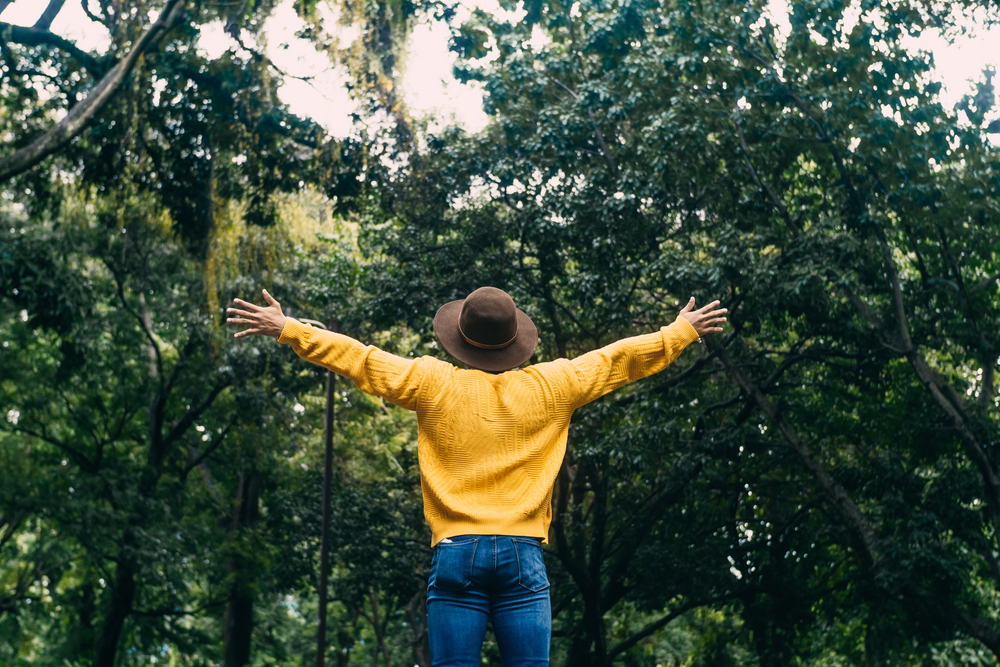 A,Young,Man,Traveler,With,Camera,Y,Backpack,Raising,Arms