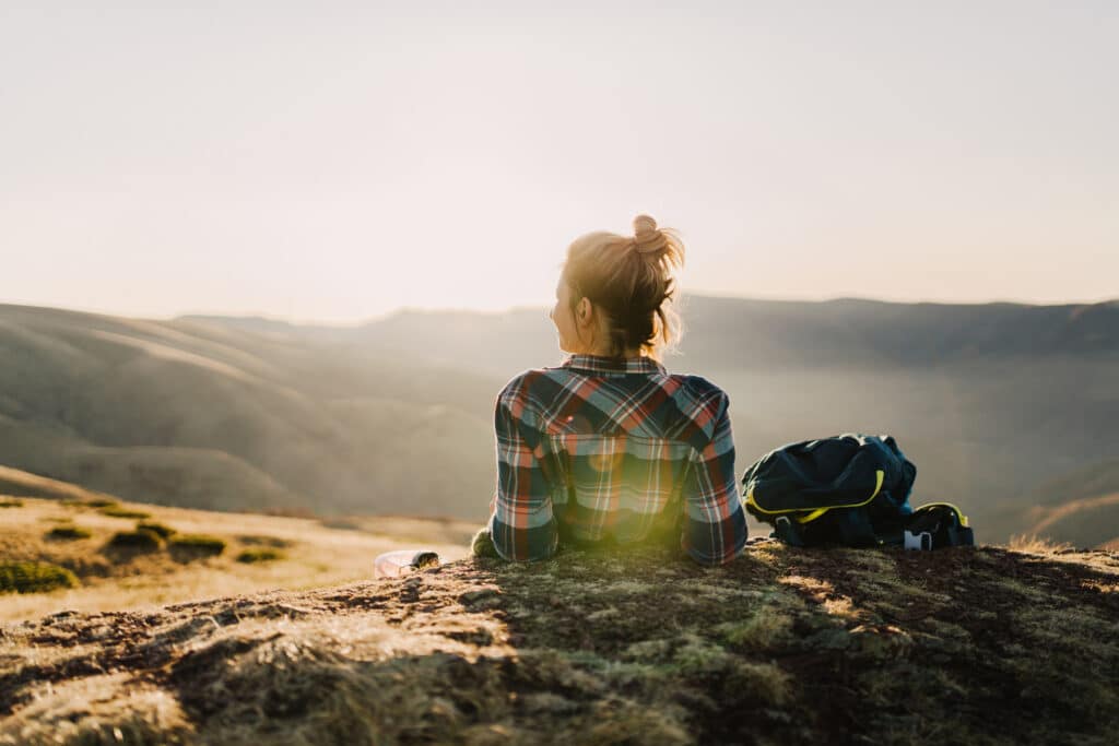 A person gazing at a tranquil mountain view, representing the path to recovery from comorbid substance use and mental health disorders.