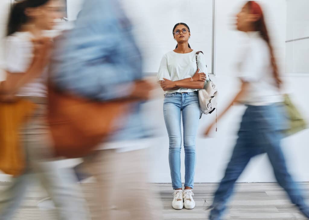 College student walking on campus looking stressed, symbolizing the mental health and substance use challenges faced by many during the back-to-school season.