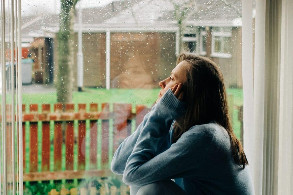 A woman struggling with addiction looking out the window