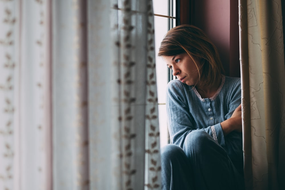 A woman struggling with methamphetamine use looking out a window