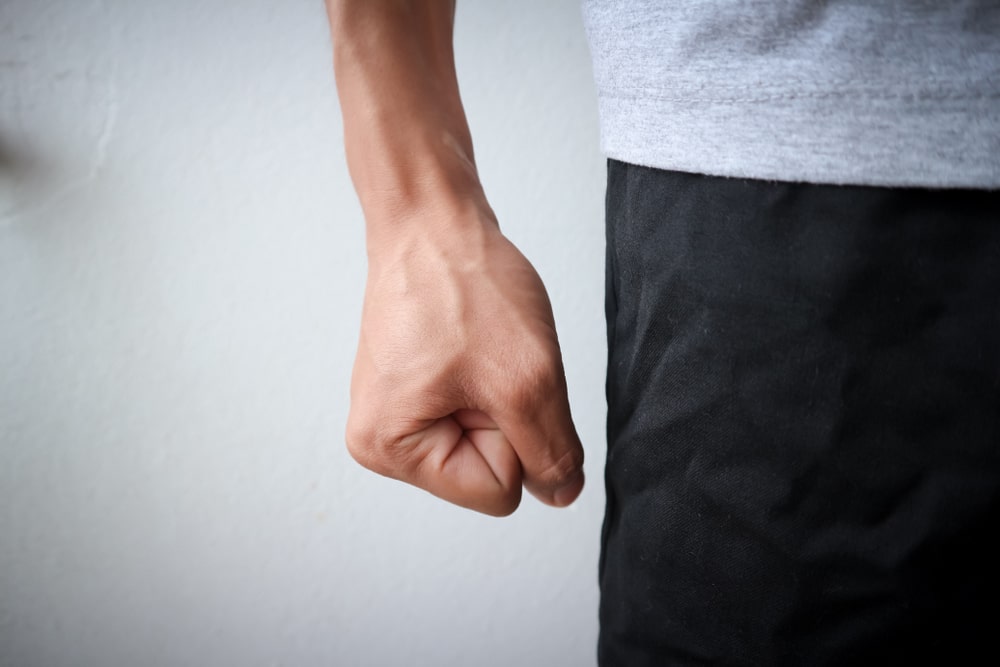A close-up shot of an angry man making a fist
