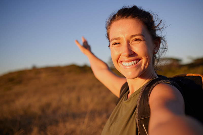 Young woman smiling as she hikes a mountain Young woman smiling as she hikes a mountain
